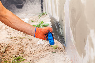 worker holding special hand tool used to apply stucco to a wall