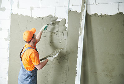 stucco contractor using hand trowel to texture wall