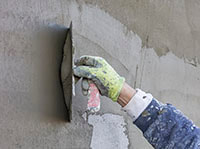 close-up of worker showing detailed stucco installation on home