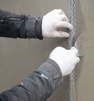 stucco repair on edge of wall using strengthening metal edge 