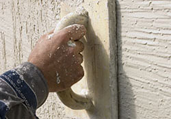 worker texturing wall with a special hand tool